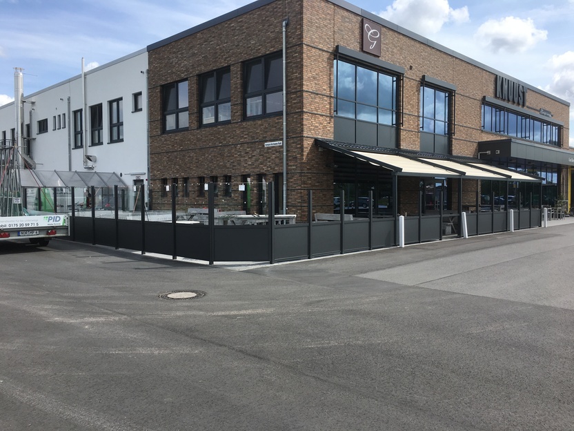 Gastronomielokalität mit ausgefahrener großer Markise an Straße