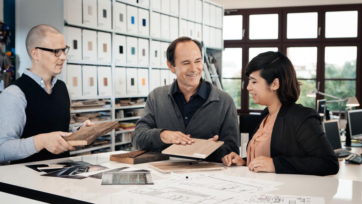 Beratung zu verschiedenen Holzoberflächen zwischen Berater und Eheleuten
