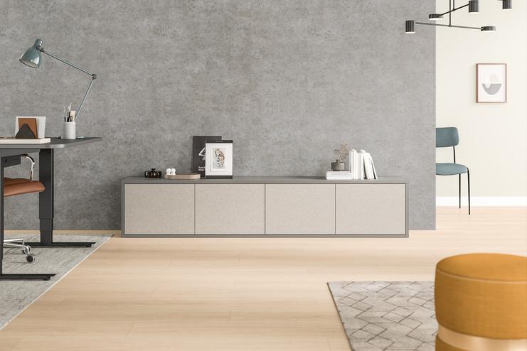 Stilvolles Sideboard nach Maß in Beige mit strukturierter Oberfläche, passend zur Betonwand im Hintergrund eines eleganten Büros.